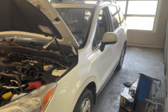 Car Maintenance near me in South Burlington, VT with Girlington Garage. Image of a white mini SUV with an open hood undergoing car maintenance in preparation for the spring season
